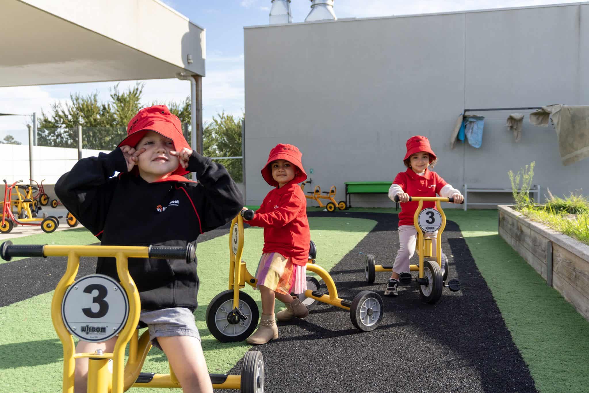 Children riding bikes outdoors at Billy-beet Montessori