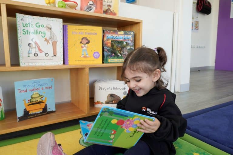 A child enjoying books in the reading corner at Billy-beet